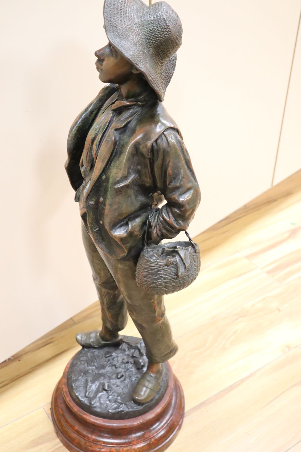 After H. Wiesse. A large patinated spelter figure of a fruit picker entitled Siffleur signed, total height 74cm